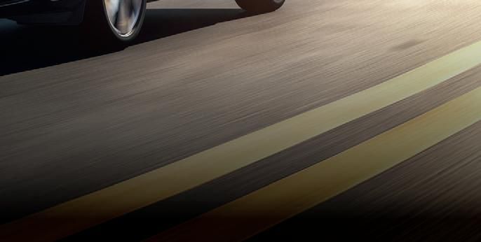 Överblick av en väg med bilhjul, fokus på vägens linjer som symboliserar bilfärd.